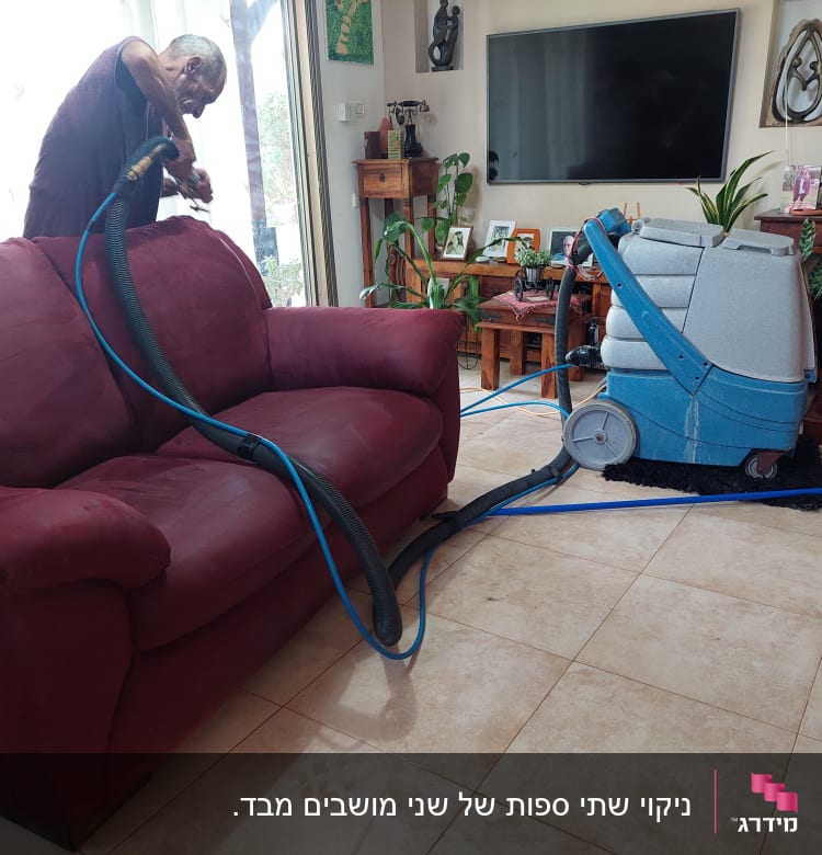 אדם מנקה ספה עם מכונת ניקוי מקצועית